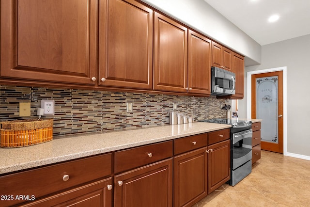 kitchen featuring light tile patterned floors, decorative backsplash, light stone counters, and stainless steel appliances