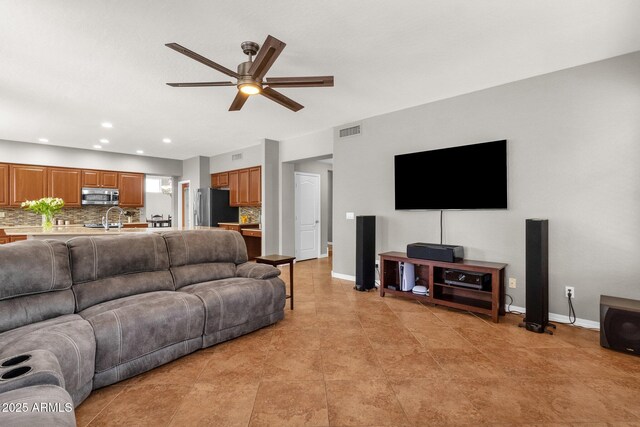 tiled living room with ceiling fan and sink