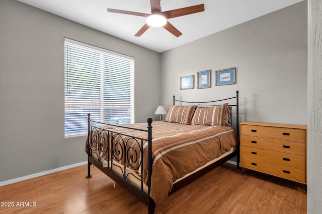 bedroom featuring ceiling fan, multiple windows, and wood-type flooring