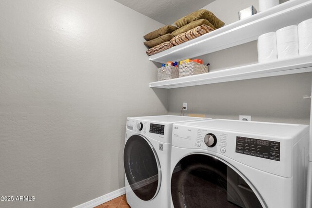 clothes washing area with light tile patterned floors and washer and dryer