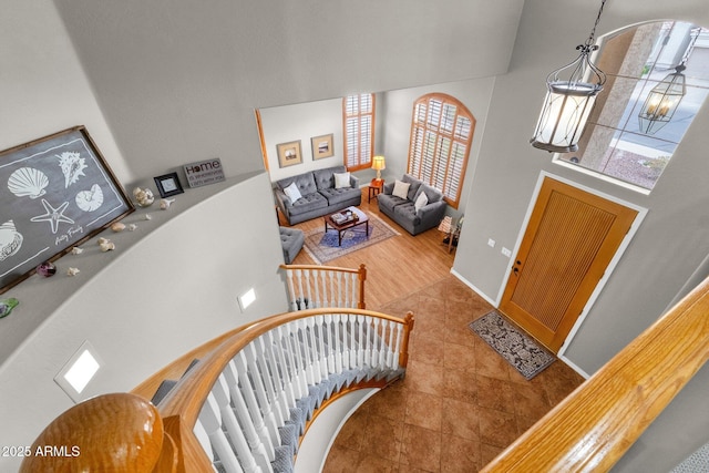 foyer featuring a wealth of natural light, tile patterned floors, a high ceiling, and a notable chandelier