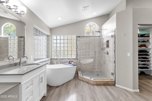 bathroom featuring hardwood / wood-style flooring, vanity, lofted ceiling, and separate shower and tub