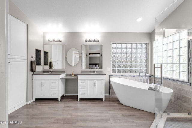 bathroom with vanity, wood-type flooring, vaulted ceiling, and plus walk in shower