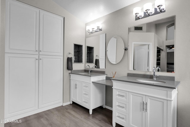 bathroom with lofted ceiling, vanity, and wood-type flooring