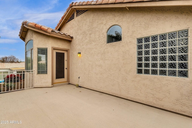 view of exterior entry with a patio