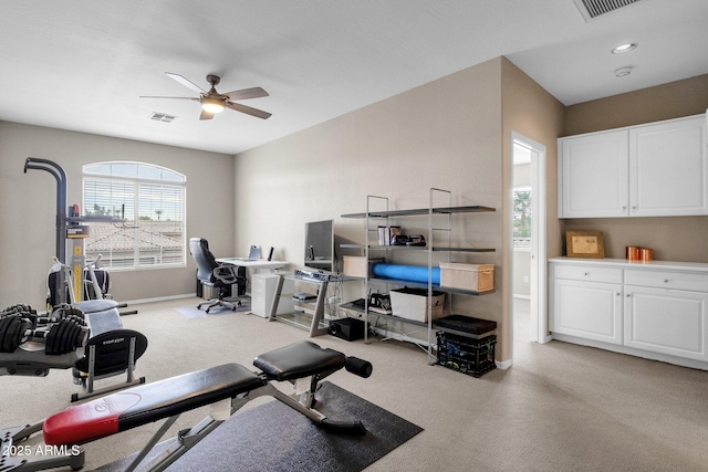 workout room with light carpet and ceiling fan