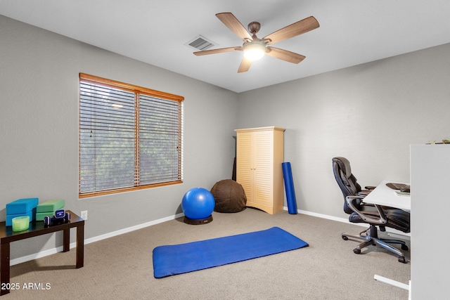 carpeted home office featuring ceiling fan