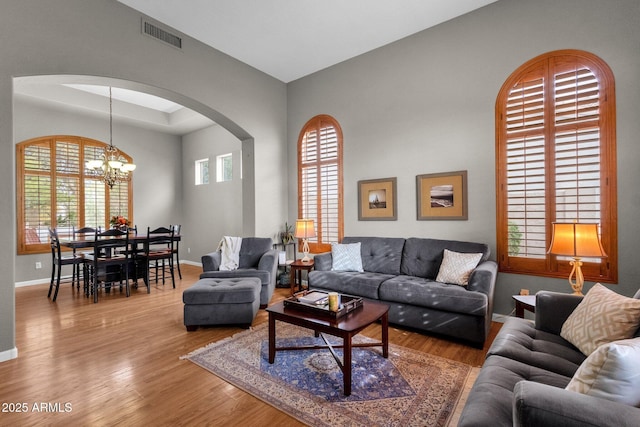 living room with an inviting chandelier and light hardwood / wood-style flooring