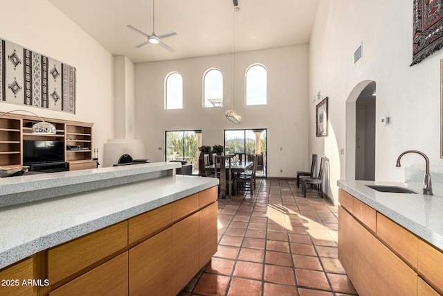 kitchen with visible vents, arched walkways, a sink, and open floor plan