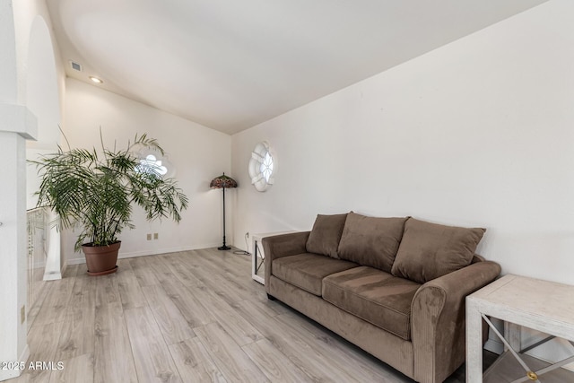 living area with visible vents, light wood-style flooring, and baseboards