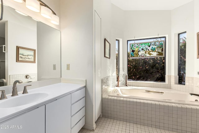 full bathroom featuring a garden tub, vanity, and tile patterned floors