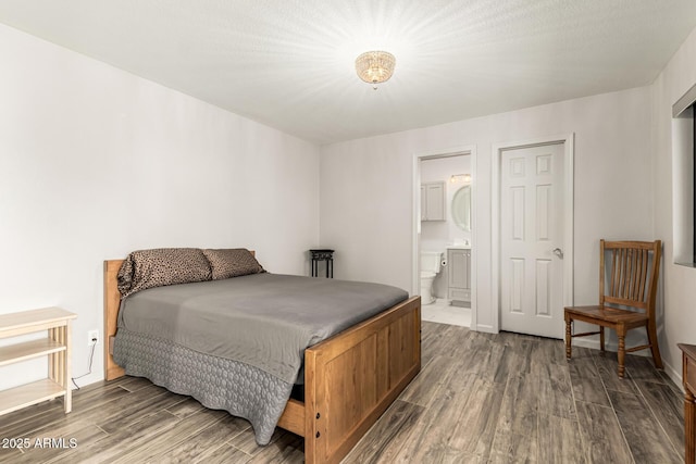 bedroom with dark wood-type flooring and ensuite bathroom