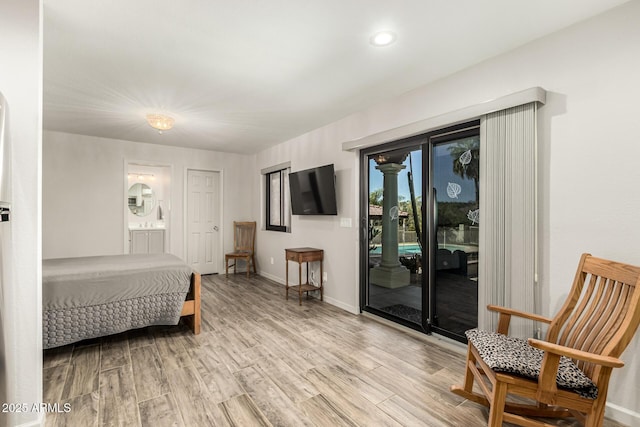 bedroom featuring access to exterior, light wood-style flooring, baseboards, and connected bathroom