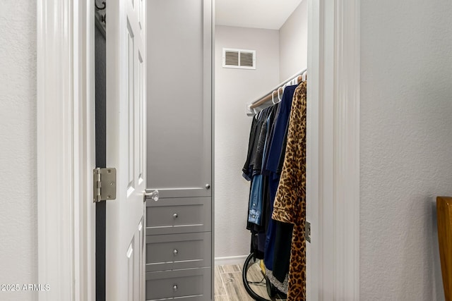 walk in closet featuring wood finished floors and visible vents