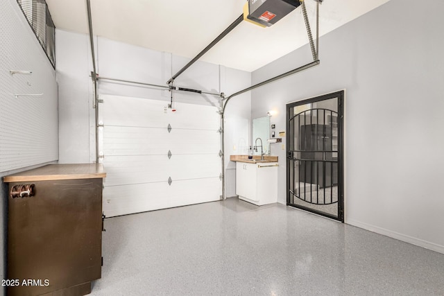 garage with baseboards, a sink, and a garage door opener