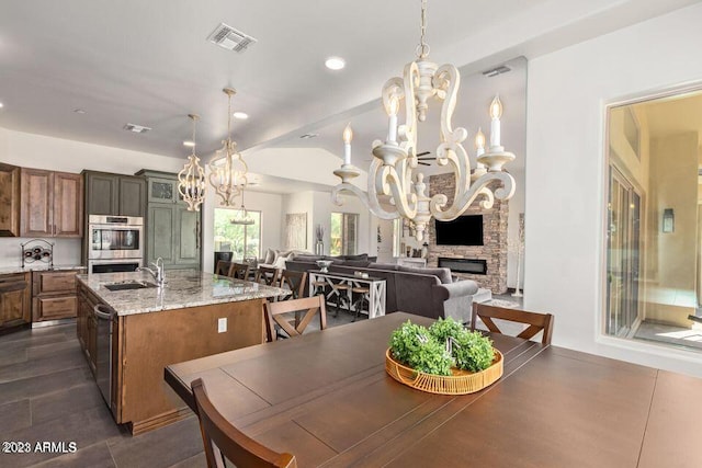 tiled dining room with a fireplace and sink