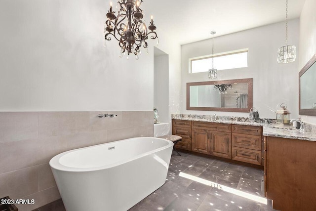 bathroom featuring tile patterned flooring, vanity, tile walls, and a bathing tub