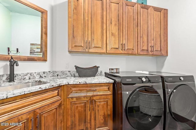 washroom with separate washer and dryer, sink, and cabinets