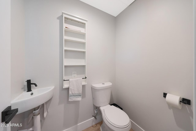 half bath featuring toilet and baseboards