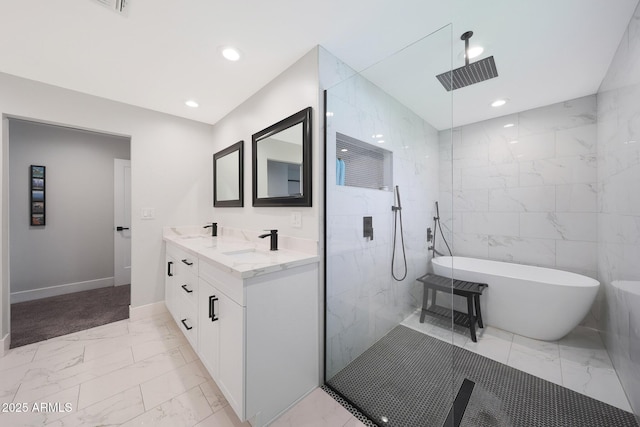 bathroom with marble finish floor, a walk in shower, recessed lighting, double vanity, and a soaking tub