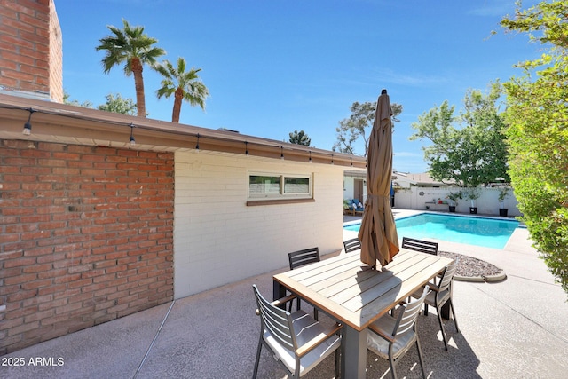 view of swimming pool with a fenced in pool, fence, outdoor dining space, and a patio area