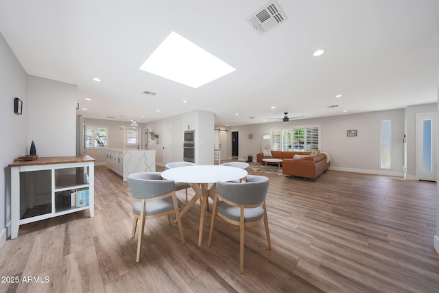 dining area with recessed lighting, visible vents, wood finished floors, and a skylight