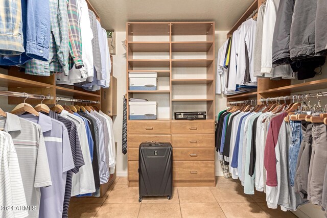 walk in closet with light tile patterned floors