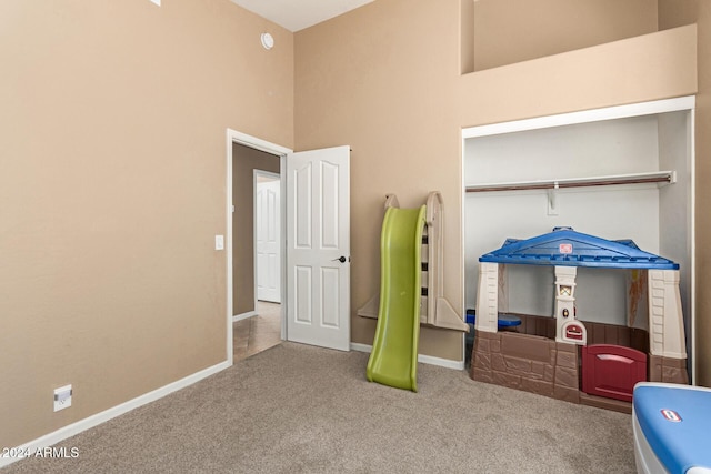 interior space featuring carpet flooring and a towering ceiling