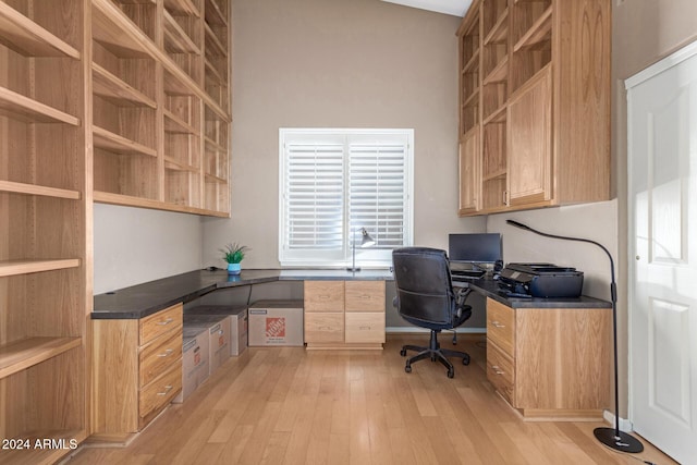 home office featuring light wood-type flooring and vaulted ceiling