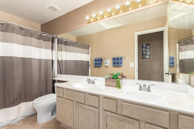 bathroom featuring tile patterned flooring, vanity, and toilet