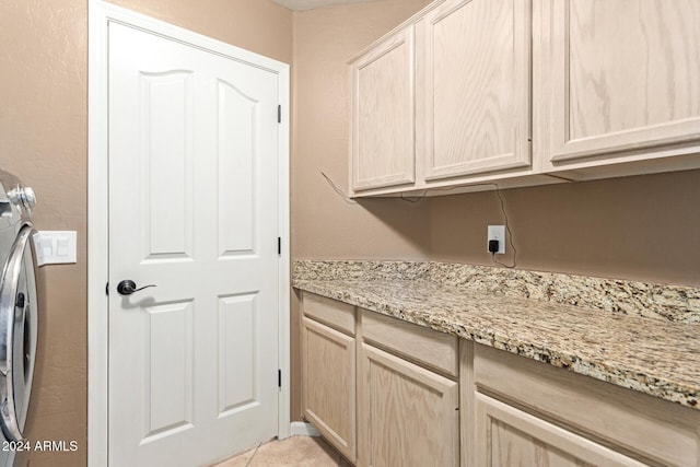 washroom with cabinets and washing machine and dryer