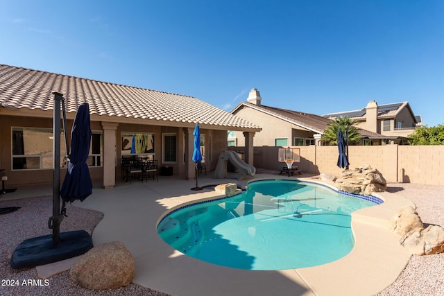 view of pool featuring a patio and a water slide