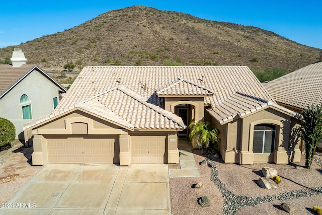 view of front of property with a mountain view and a garage