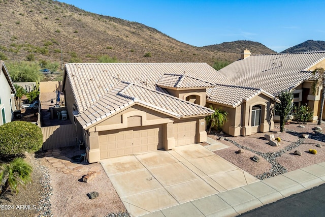 view of front of home with a mountain view and a garage