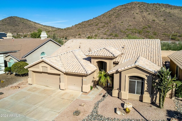 view of front of home with a mountain view and a garage