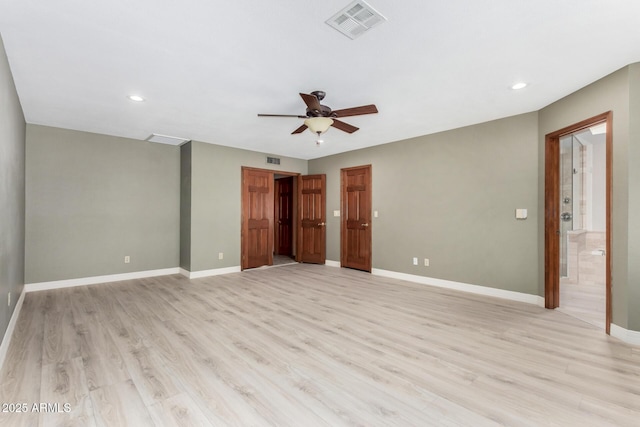 unfurnished bedroom featuring baseboards, visible vents, light wood finished floors, and ensuite bathroom