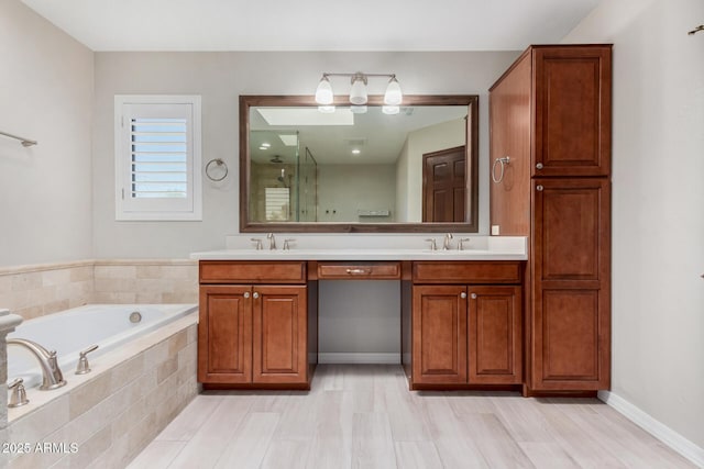 full bathroom featuring double vanity, a garden tub, a sink, and a stall shower