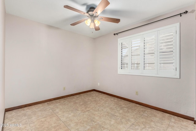 unfurnished room with ceiling fan and baseboards