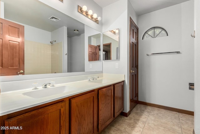 bathroom featuring double vanity, visible vents, a sink, and tile patterned floors