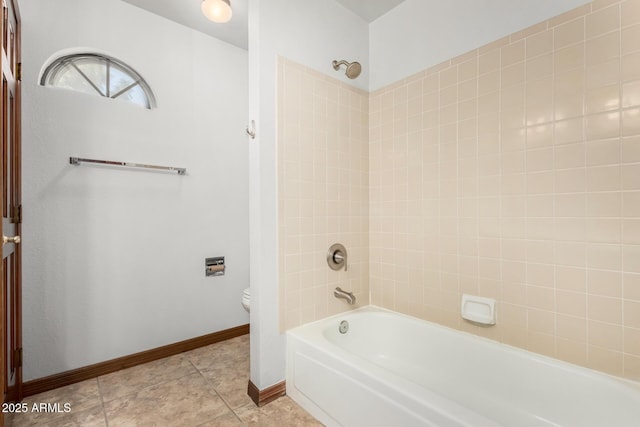 full bath featuring washtub / shower combination, tile patterned flooring, baseboards, and toilet