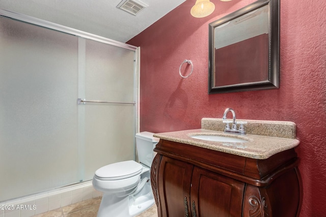 bathroom with a textured wall, toilet, vanity, visible vents, and a shower stall