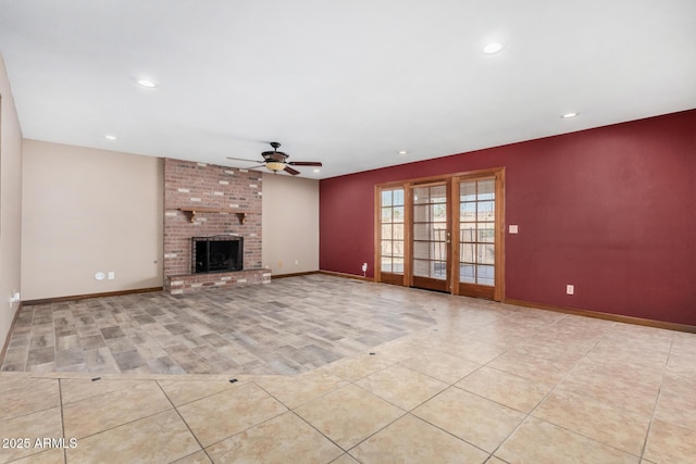 unfurnished living room featuring light tile patterned floors, a ceiling fan, baseboards, french doors, and a brick fireplace