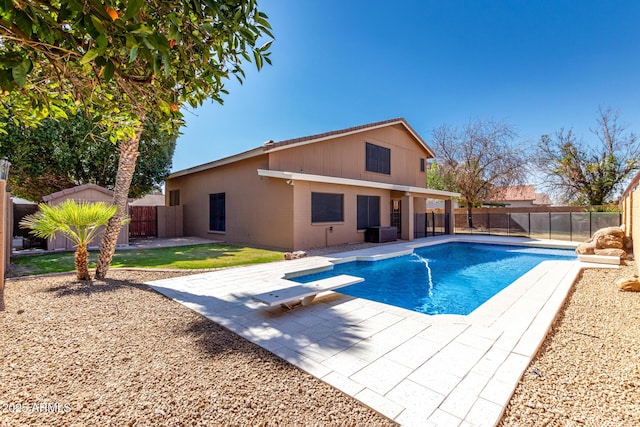 view of pool with a diving board, a patio, and a fenced backyard