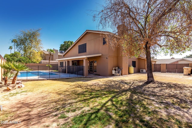 rear view of house featuring a fenced backyard and a fenced in pool