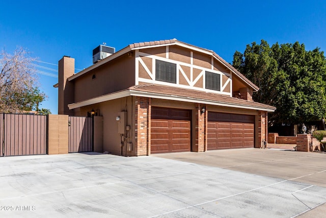 view of front facade with a garage, driveway, central air condition unit, and stucco siding