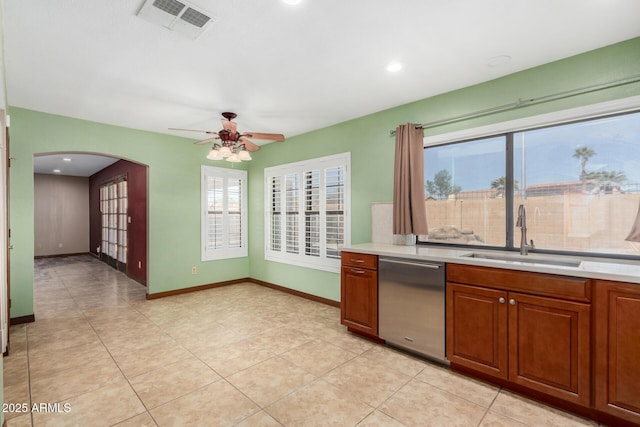 kitchen featuring arched walkways, visible vents, dishwasher, light countertops, and a sink