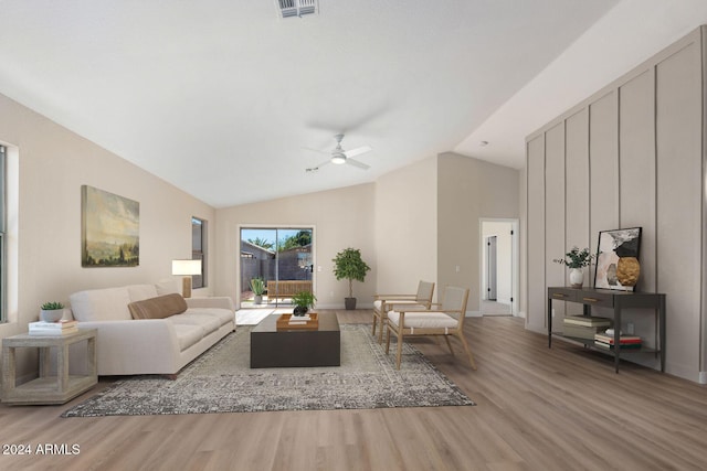 living room featuring ceiling fan, light hardwood / wood-style flooring, and vaulted ceiling