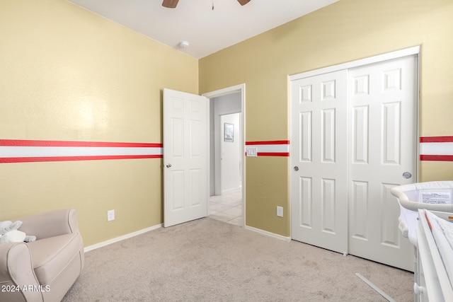 unfurnished bedroom featuring light colored carpet, ceiling fan, and a closet