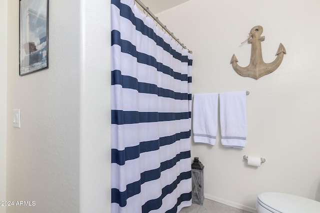 bathroom featuring toilet and a shower with curtain