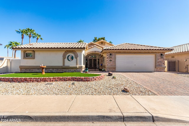 mediterranean / spanish-style house featuring a garage and a front lawn